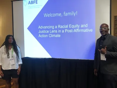 ABFE presenters posing and smiling in front of a projected slideshow at ForumCon24